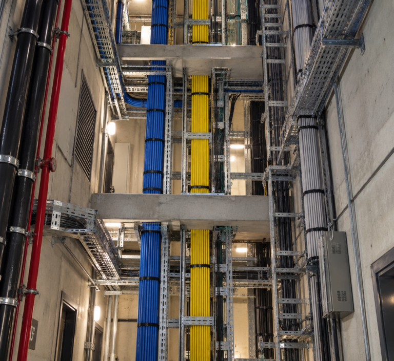 Shaft de redes com cabos e eletrocalhas organizados em infraestrutura predial